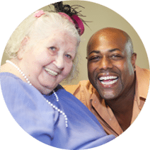 an elderly resident smiling with a caregiver