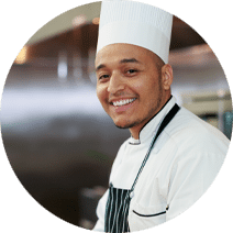 smiling chef wearing a chef's hat and an apron