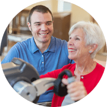 a smiling rehab nurse assisting a happy elderly resident in the rehab gym